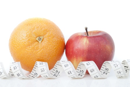 Orange and apple with a measuring tape on a white background.の写真素材