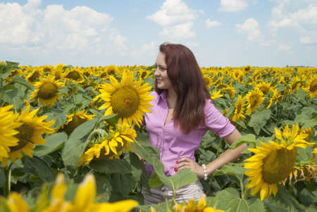 Beautiful girl in a field of sunflowers.の写真素材