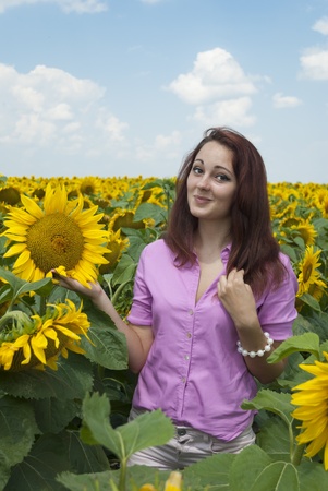 Beautiful girl in a field of sunflowers.の写真素材