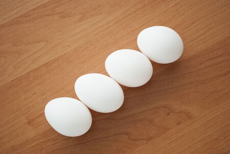 Chicken eggs on a wooden tableの写真素材