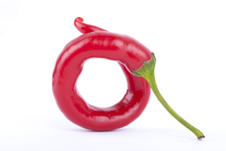 Twisted pod of red pepper chili on a white background の写真素材