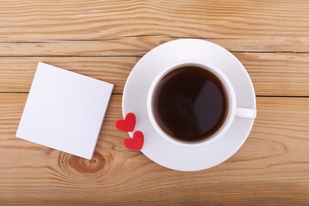 Cup of coffee and two hearts on a wooden background  の写真素材