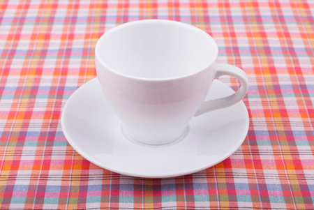 Coffee cup on a checkered tablecloth の写真素材