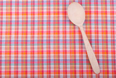 Wooden spoon on checkered tablecloth の写真素材