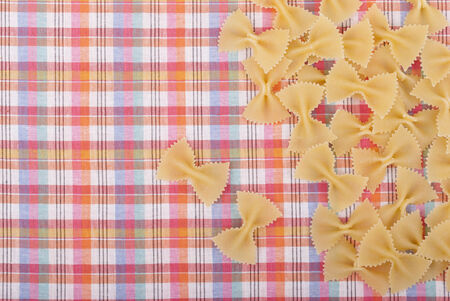 Uncooked pasta on the kitchen tablecloth.の写真素材
