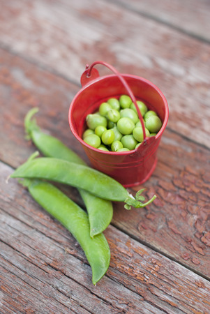 Peas in a bucket on a wooden background.の写真素材