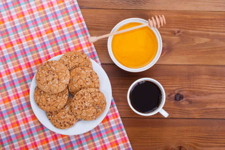 Coffee cup biscuits and honey lies on a wooden background.の写真素材