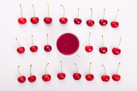 Sweet cherries and berries mug with compote. Top view .