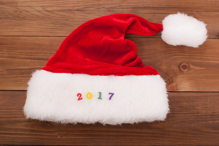 Hat of Santa Claus and the numbers 2017 on the wooden background.の写真素材