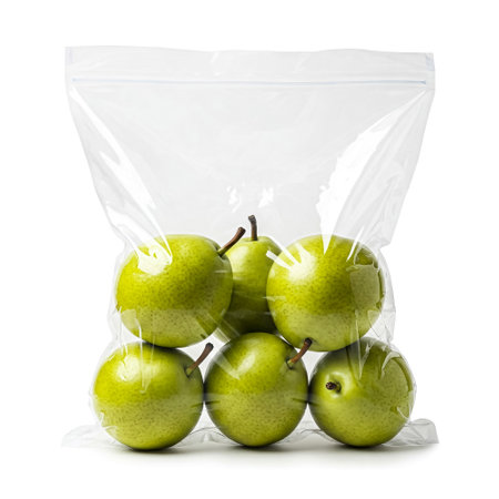 Six bright green apples are neatly arranged inside a clear plastic bag, showing their fresh and shiny surface. Ideal for quick storage or immediate use in recipes.の素材