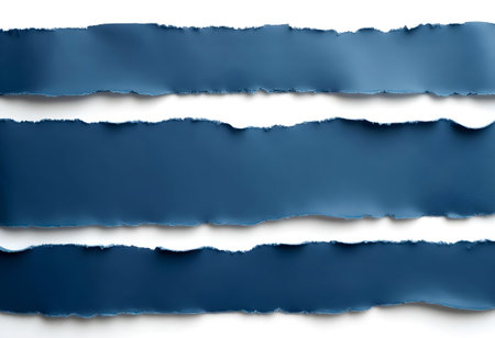 Three uneven strips of deep blue paper are placed horizontally on a white surface. Their torn edges create a dynamic and artistic contrast, emphasizing texture and color richness.の素材