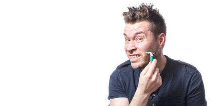 Portrait of handsome man getting hurt while shaving with a razor, isolated on a white background,...