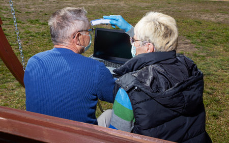 Coronavirus pandemic. Covid 19 An elderly couple a man and a woman in medical masks in front of a...