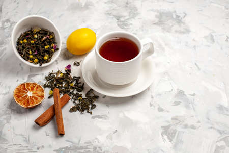 front view cup of tea with lemon and cinnamon on white background tea drink ceremony fruitの写真素材