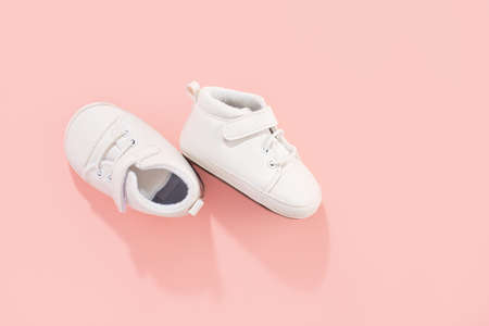 Baby first shoes on pink pastel background. Family or motherhood concept.の写真素材