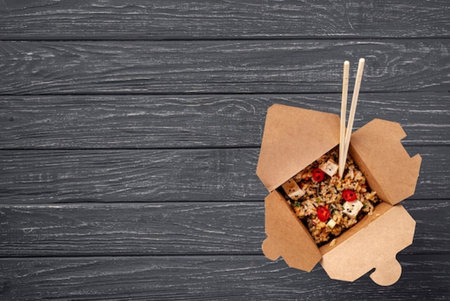 Top view of box with healthy food and chopsticks on wooden backgroundの写真素材