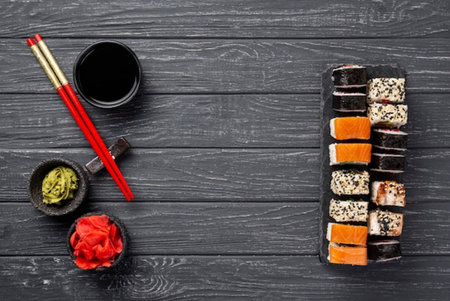 Sushi set with chopsticks, soy sauce and ginger on wooden backgroundの写真素材