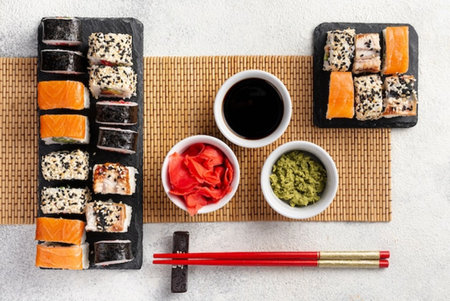 Sushi set on stone background. Sushi rolls with salmon, eel, caviar, wasabi, ginger, soy sauce. Top viewの写真素材