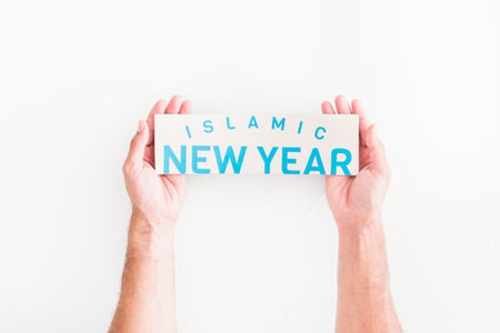 Top view of hands holding a card with new year message on white backgroundの写真素材