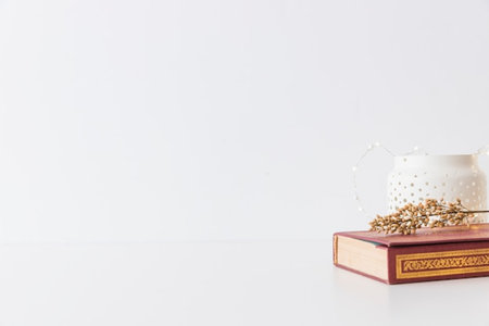 Old book and teapot on white background with space for textの写真素材