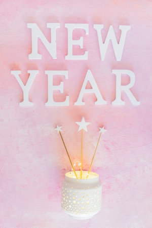 New Year card with candles on a pink background. Copy space.の写真素材