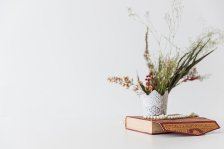 Book and vase of dried flowers on white background. Copy space.の写真素材