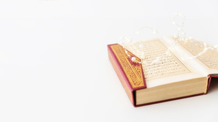 Open book with christmas ornaments on a white background.の写真素材