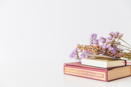 Books and dried flowers on white background with copy space for text.の写真素材