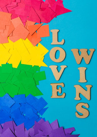 Colorful paper with the word love and wooden letters on a blue backgroundの写真素材