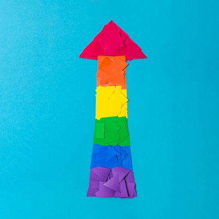 Colorful origami arrow isolated on blue background. Concept of success.の写真素材