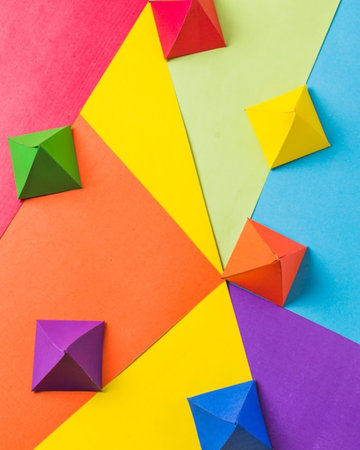 Colorful origami paper planes on colorful background. Flat lay.