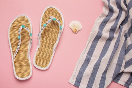 Flat lay composition with flip flops and seashell on pink backgroundの写真素材