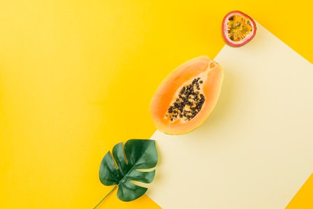 Papaya fruit on yellow background. Tropical concept. Flat lay, top view.の写真素材