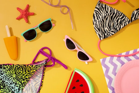Flat lay composition with swimsuit, sunglasses and watermelon on yellow backgroundの写真素材