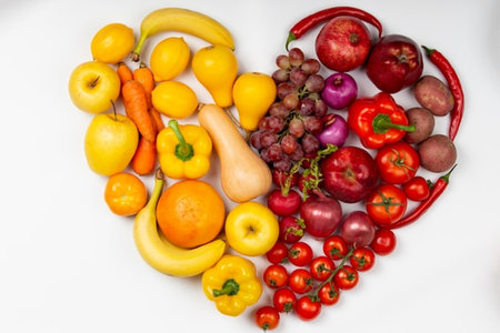 Fruits and vegetables in the shape of a heart on a white backgroundの写真素材