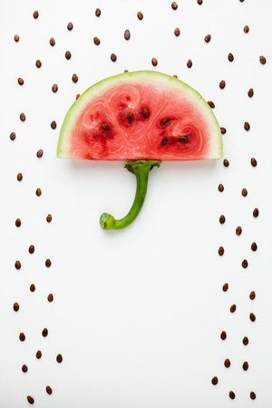 Watermelon slice and seeds on white background. Flat lay, top view.