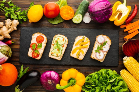 Healthy vegetarian sandwiches with vegetables on wooden background. Top view.の写真素材