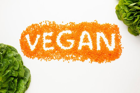 Vegan word made of red lentils and green lettuce on white backgroundの写真素材