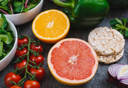 Healthy eating concept. Fresh vegetables, fruits and crispbread on dark background