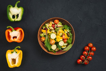 Fresh vegetable salad in bowl on black background. Top view, flat layの写真素材