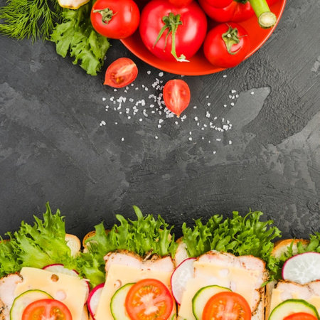 Sandwiches with cheese and vegetables on a black stone background. Top viewの写真素材