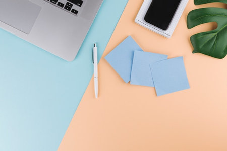 Creative flat lay overhead top view photo of workspace desk with laptop smartphone and stationery...