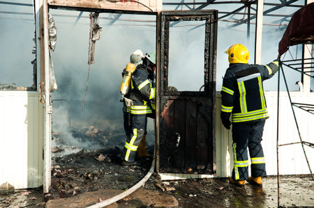 Kiev, Ukraine - June 16, 2015: Firefighters extinguish a large fire at Troyeschina market with water...