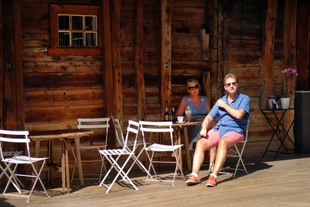 Bergen, Norway -  July 20, 2014: Tourists in the wooden outdoor cafe. Tourism is an important income source for the city. The hotels in the city may be full at times.のeditorial素材