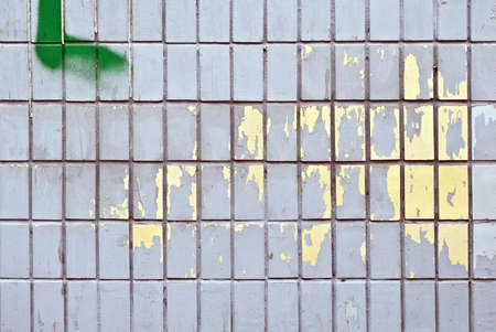 Peeling paint on a wall of tiles as a background imageの写真素材