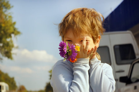 Boy with bouquet of wild flowers in a hand