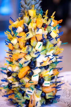 Many canapes of exotic fruits - kiwi, grape, mandarin, pineapple. The original filing of fruit snacks at celebration. Catering outdoors, summerの写真素材