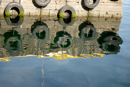 Concrete pier, with hanging tire buffersの写真素材