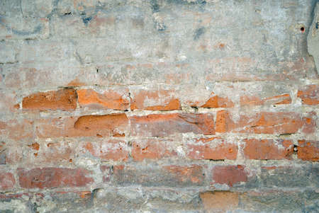 Abandoned grunge cracked brick stucco wall backgroundの写真素材