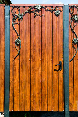 Rustic wooden gate with wrought iron ornateの写真素材